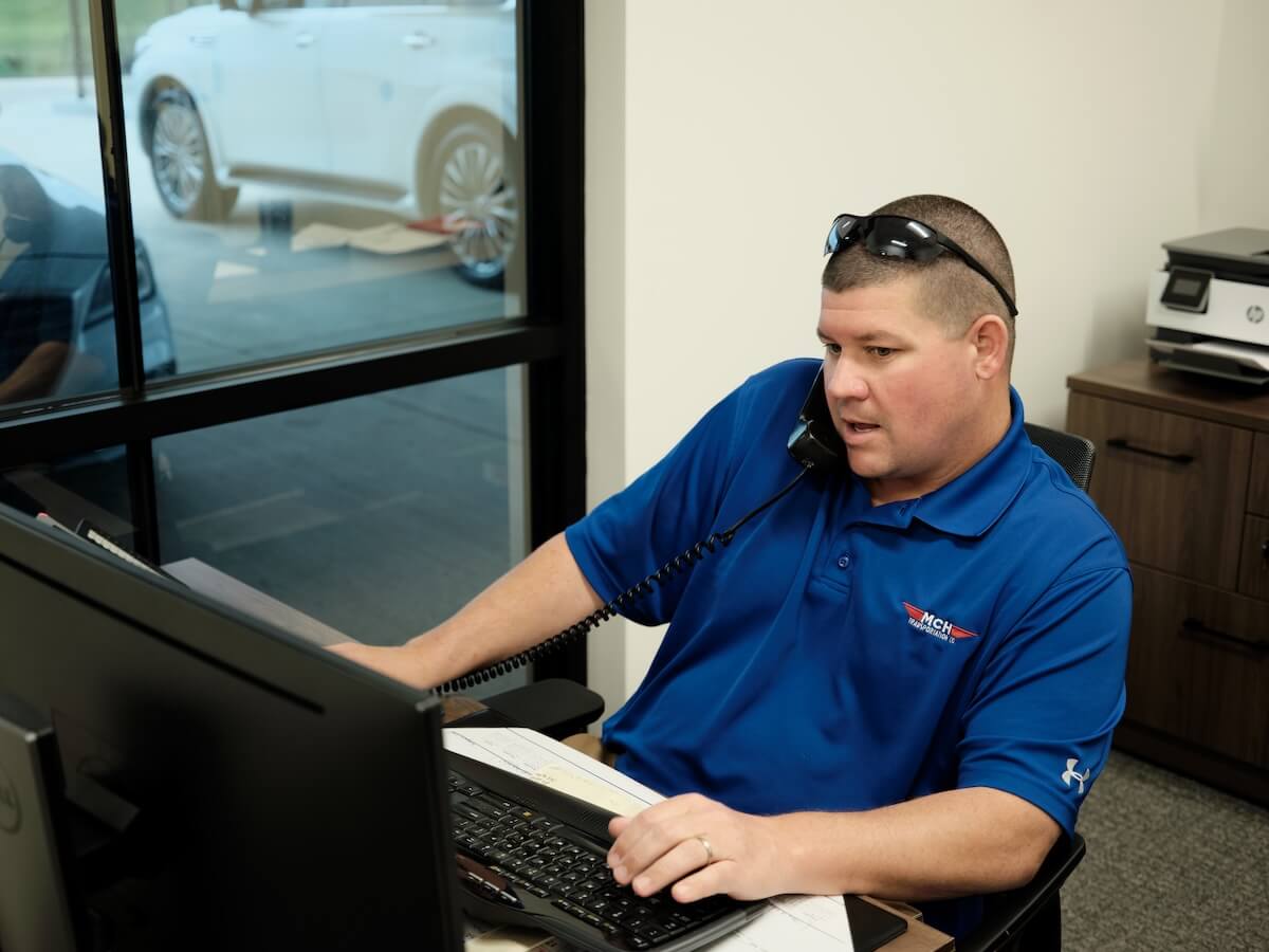 An MCH Transportation Company employee on the phone at the office